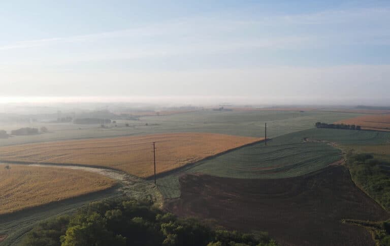 An aerial view of a field with a misty sky.