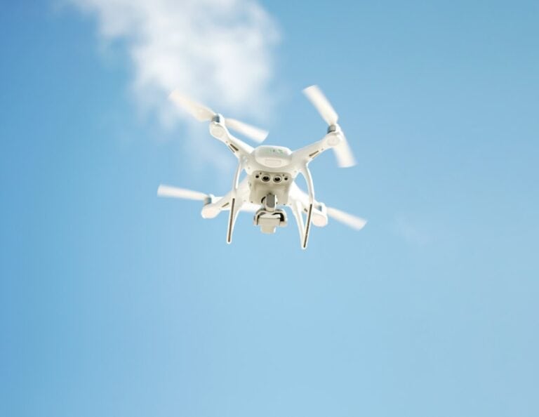 Quadcopter drone flying against clear blue sky
